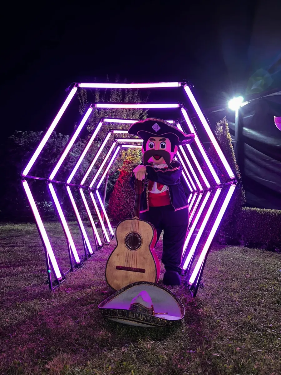 El muñeco Toribio González, mascota del mariachi, con su guitarra entre luces violetas